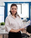 Project manager looking at camera smiling, standing in middle of conference room Royalty Free Stock Photo