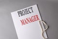 PROJECT MANAGER text on white folder on grey background Royalty Free Stock Photo