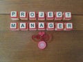 Project Manager word on wood background with red and white accents