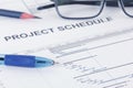 Project schedule document with pen, pencil, eyeglases and gantt chart Royalty Free Stock Photo