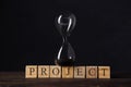 Project timeline countdown, launch business or start up company, hourglass or sandglass on wooden cube blocks with