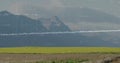 Projecting digital waveform overlay across rural farmland with mountain range, showing numeric data Royalty Free Stock Photo