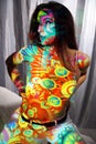 Projection with colorful pattern on pretty woman kneeling looks like body painting Royalty Free Stock Photo