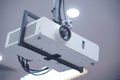 Projector hang on black ceiling in big meeting room or university. Closeup projector for cinema and presentation Royalty Free Stock Photo