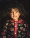 Sweet little girl indoors with curly hair. Nepalese child girl