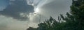 Skyscape: late afternoon view of sun rays filter through dark clouds Royalty Free Stock Photo