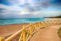 Promenade around the sea with a wooden railing and a view of the water. The clear turquoise sea of the Atlantic ocean on which are