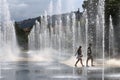 Walking couple between fountains, Promenade du Paillon, Nice, France