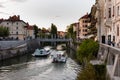 The promenade on the Ljubljanica river in the slovenian capital city Ljubljana with the Cobblers bridge and tourist boats on sunny