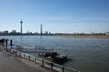 Promenade riverside and bridge toward pier, pontoon or buoy over Rhine River suspension bridge and Rhine tower in DÃÂ¼sseldorf.