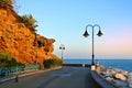 Promenade of Torremolinos, a road, rocks, blooming bushes and Mediterranean sea