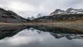 Prominent mountain reflecting in alpine lake during overcast day, Pano, Mt Assiniboine PP, Canada