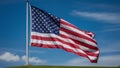 A prominently displayed American flag, billowing in the wind against a clear blue sky