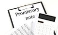 PROMISSORY NOTE text on folder with chart and calculator