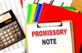 PROMISSORY NOTE text written on paper clipboard with chart and calculator