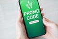 Promo code Discount coupon number field on mobile phone screen. Business and marketing concept.