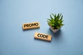 Promocode - word from wooden blocks with letters, coupon, promotion code, promo code concept, top view on blue background