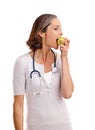 Promoting healthy eating. Cropped studio shot of a mature female doctor eating an apple. Royalty Free Stock Photo