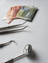 dentist utensils for oral review and european banknotes