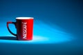 Promotional red Nescafe mug on blue background Royalty Free Stock Photo