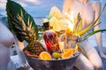 Promotional shot of rum bowl with ice palm leaves pineapple orange fireworks Royalty Free Stock Photo