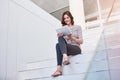 Prompt responses make for great email etiquette. Shot of a young businesswoman using a digital tablet on the stairs in a