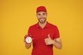 Promptness and punctuality. Delivery time. Delivery courier with clock. Delivery man holding clock. Shipping services Royalty Free Stock Photo