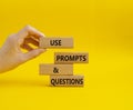 Prompts and Questions symbol. Concept word. Use Prompts and Questions on wooden blocks. Beautiful yellow background. Businessman Royalty Free Stock Photo