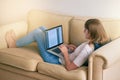 Proof reading that essay one last time. a young woman using her laptop while sitting on the couch at home.