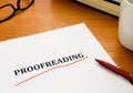 Proofreading word on white sheet with red pen Royalty Free Stock Photo