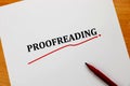 Proofreading word on white sheet with red pen Royalty Free Stock Photo