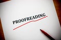 Proofreading word on white sheet with red pen Royalty Free Stock Photo