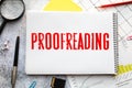 proofreading word on white sheet with red pen on wooden table Royalty Free Stock Photo