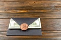 Prop Money Dollars in black envelope.Bitcoin as a seal.Brown wooden background