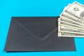 Prop Money Dollars and black envelope.Light blue background