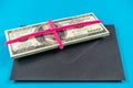 Prop Money Dollars and black envelope.Light blue background