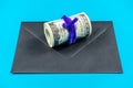 Prop Money Dollars and black envelope.Light blue background