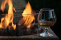 Close-up of gas fire pit with a snifter of cognac