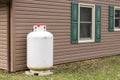 Propane tank at a house. Royalty Free Stock Photo