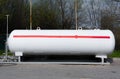 Propane. White propane gas tank with red stripe flammable gas. Large tank with gas filling under pressure outdoor. Stock photo