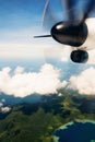 Propeller aircraft wing over tropical island Royalty Free Stock Photo