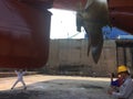 Propeller of the ship ,five blades, and rudder repairing, cleaning and painting during dry dock checked by workers and stevedores Royalty Free Stock Photo