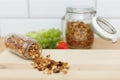 Granola scattered from a glass bottle on a wooden table