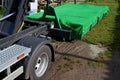 A properly covered pile of cut grass from the garden maintenance on the container is ensured by the transport and loading of the c Royalty Free Stock Photo