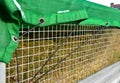 A properly covered pile of cut grass from garden maintenance on a trailer with a lattice superstructure for a larger capacity of t Royalty Free Stock Photo
