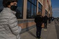 Covid-19, long line of face-masked people waiting to enter a food market in suburban Philadelphia, PA, April 11, 2020