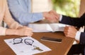 Property agreement and house key on table with real estate agent and clients shaking hands on background, closeup Royalty Free Stock Photo