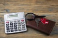 Property assessment. Miniature house with key, magnifier and calculator. Real estate concept