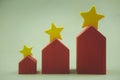 Property assessment and rate with a star. Three size red house with yellow stars on the roof for selection of the best house