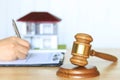 Property auction, Gavel wooden and model house with woman signing documents on the table, lawyer of home real estate and ownership